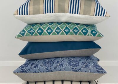 A stack of 6 cushions in blue tones
